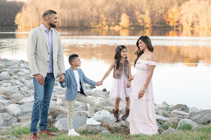 Fall outdoor family photo of family of four wearing pinks and blues  by Maryland Family Photographer