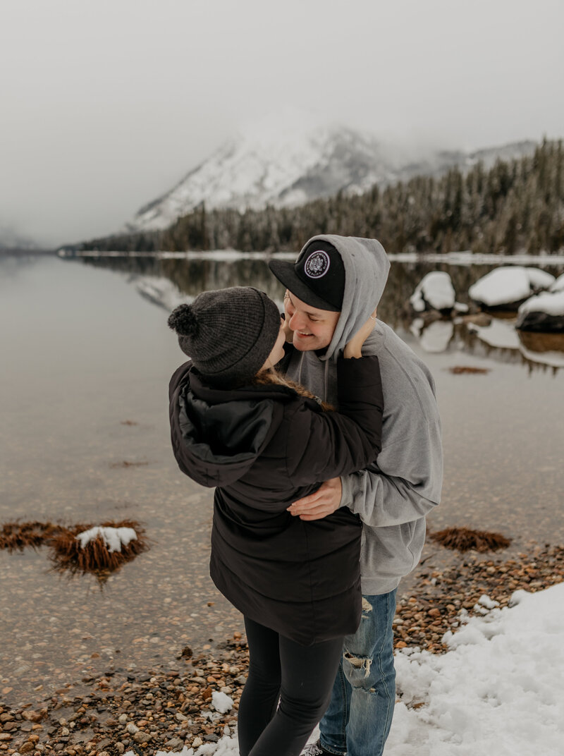 couple poses near lake during cold PNW winter