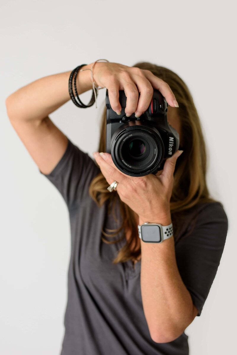 photo of photographer owner holiding camera in front of face