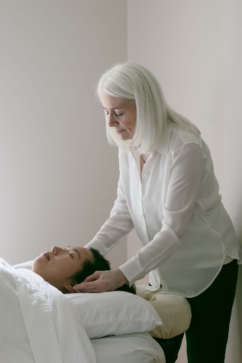photo of woman performing Reiki on another woman