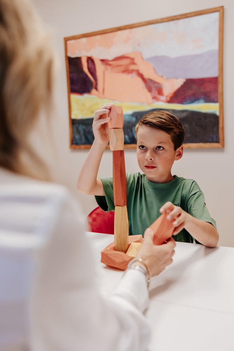 Child stacking blocks in an autism evaluation