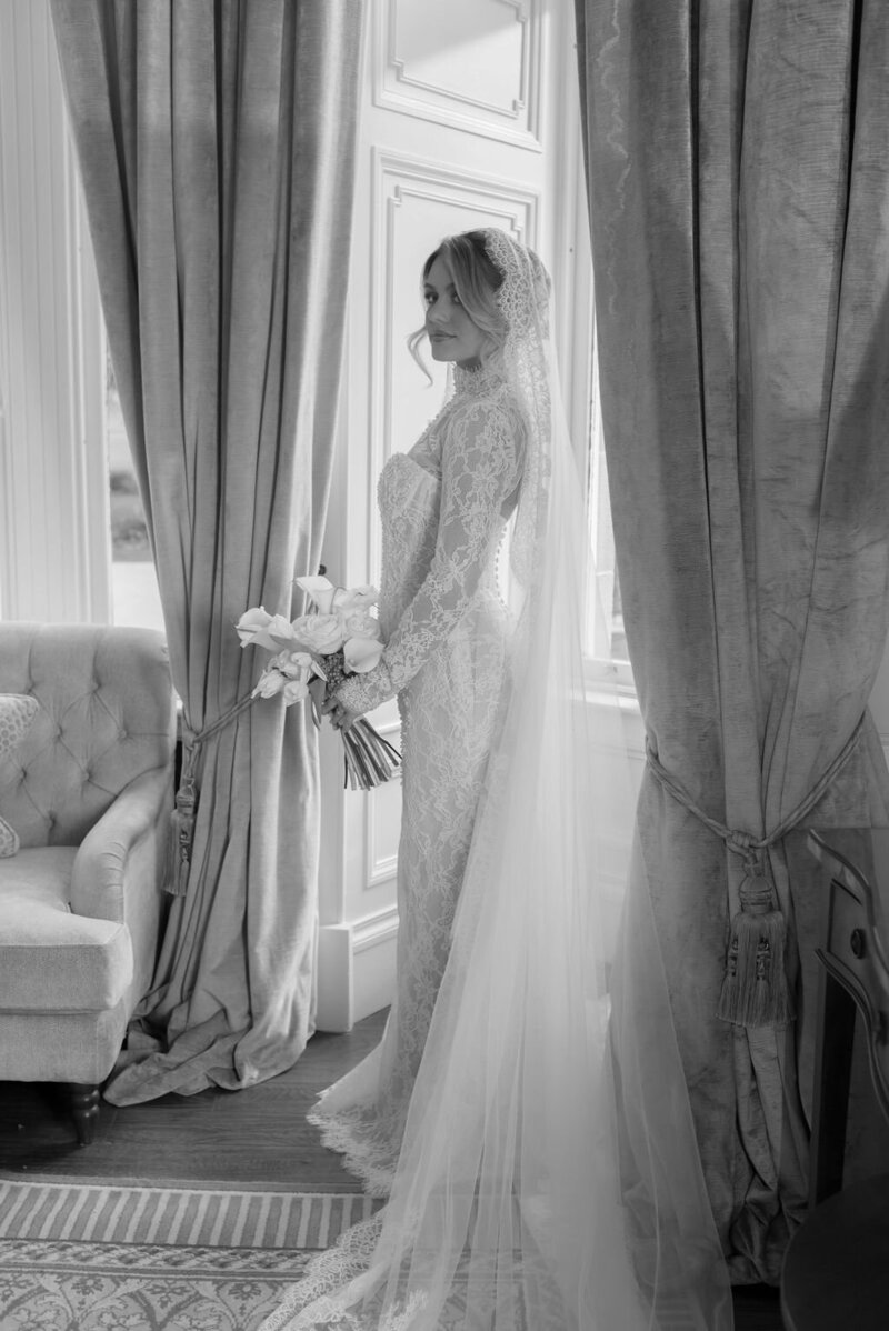 Woman crouching with flowers to kiss a flower girl bridesmaid