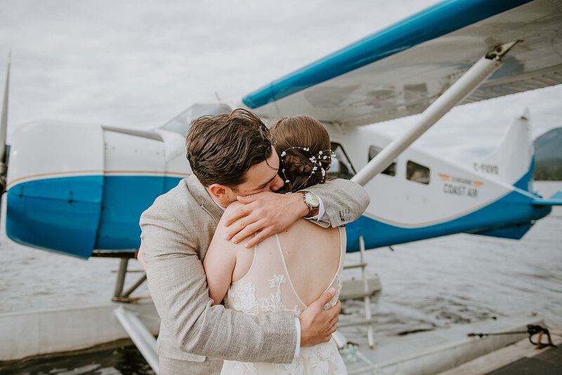 Couple hugging in front of their float plane before departing for their waterfall elopement.