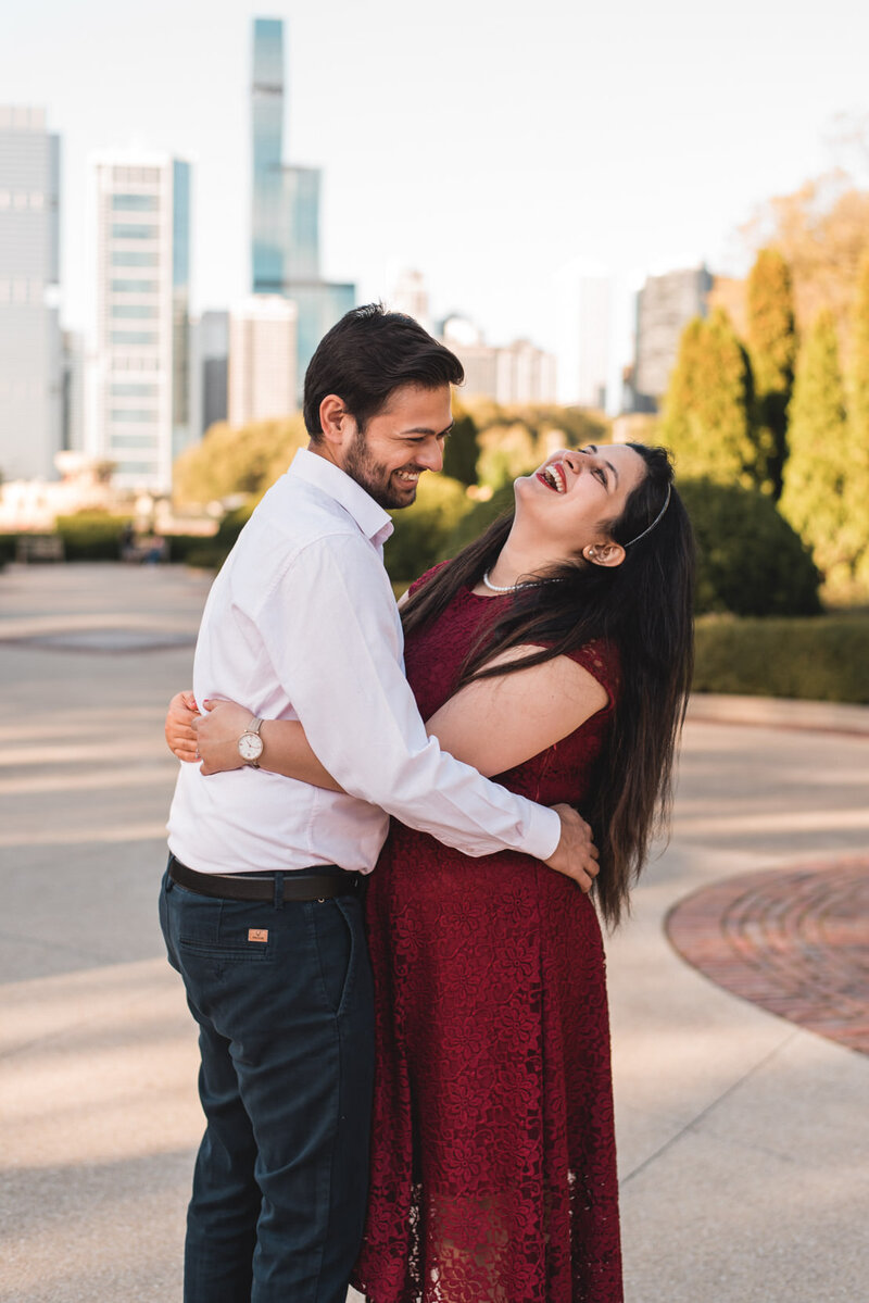 Indian couple snuggles close and laughs at the South Rose Garden near Buckingham Fountain in Chicago, IL