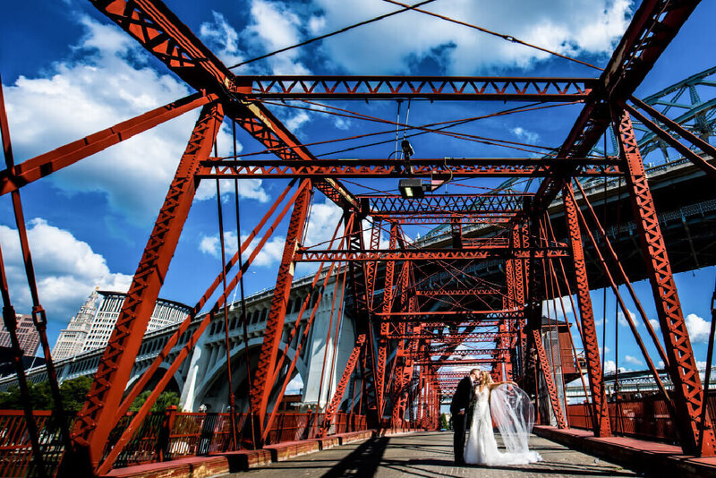 bride and groom on bridge in the flats in cleveland wedding photography captured by three and eight