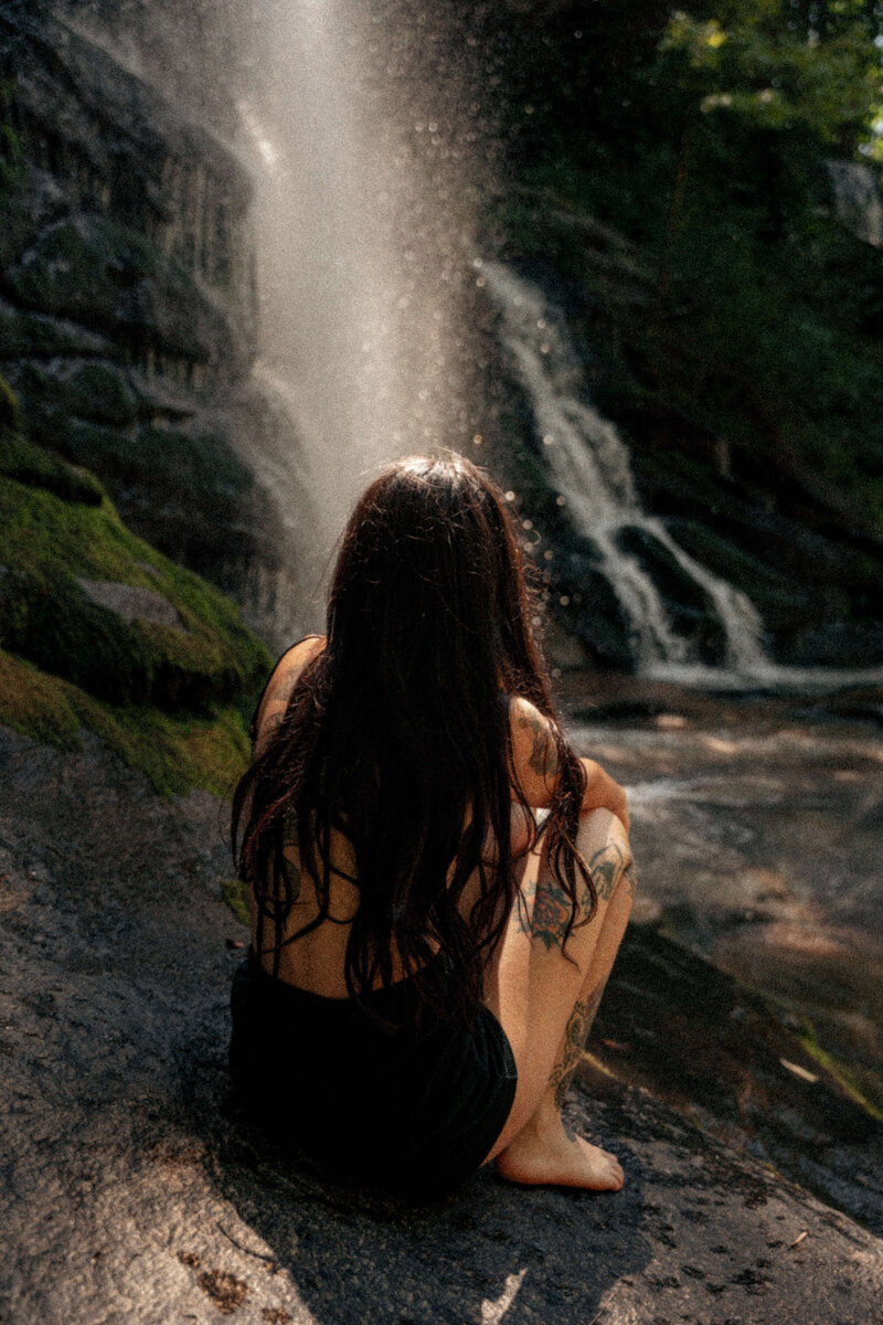 Greenville, SC branding photography featuring subject sitting in front of a waterfall