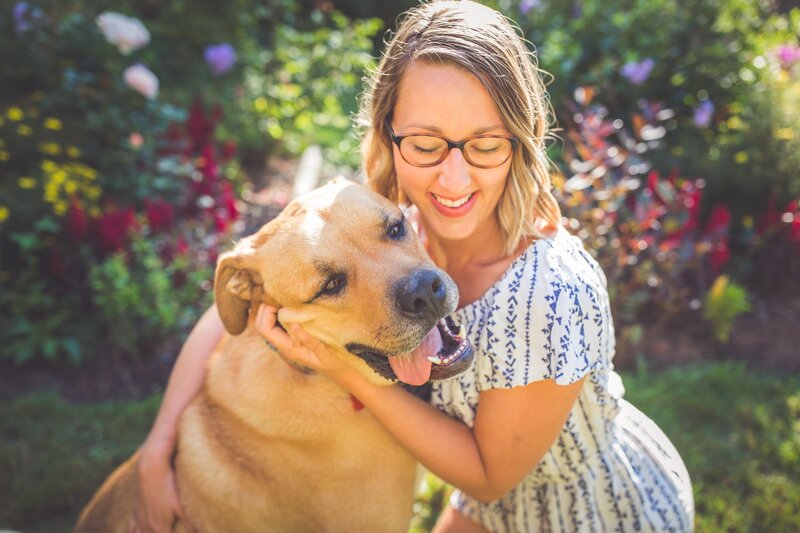 Playful photo of Chelsea Dawn in her garden with her dog