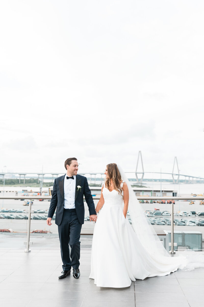Bride and Groom walking on the rooftop at the Cedar Room in Charleston. Photographed by Charleston wedding photographer Sarah Beach Photography