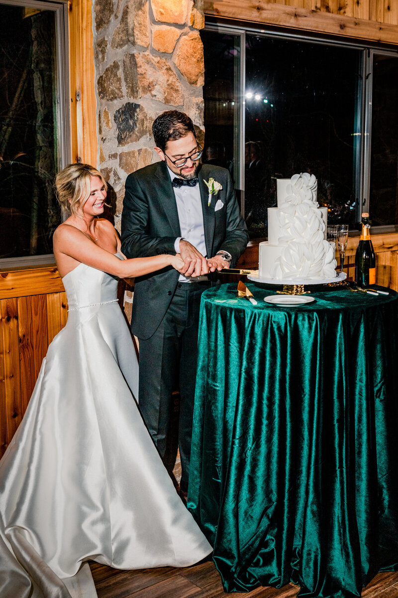 bride and groom cutting cake at indoor reception
