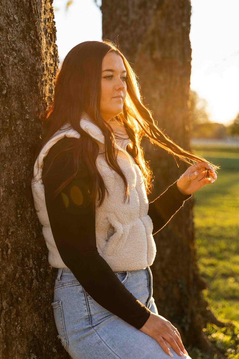 High school senior girl twirling her hair in the sunset