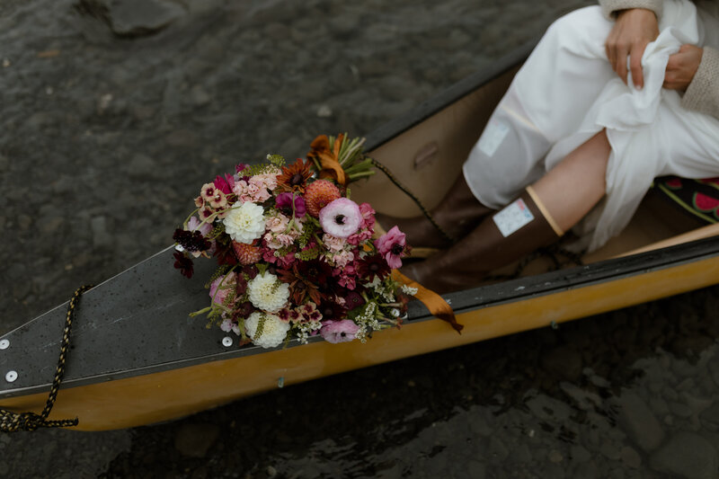 bouquet and rain boots in canoe