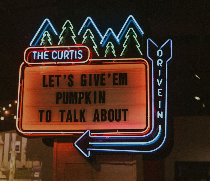 A light up sign for The Curtis that reads "Let's give 'em pumpkin to talk about"