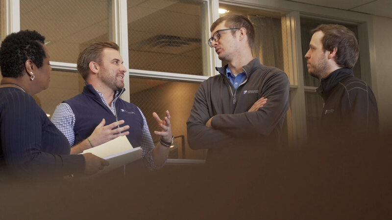 Employees at The Douglas Company, an Ohio Commercial General Contractor  talk to one another in  the halls of their headquarters