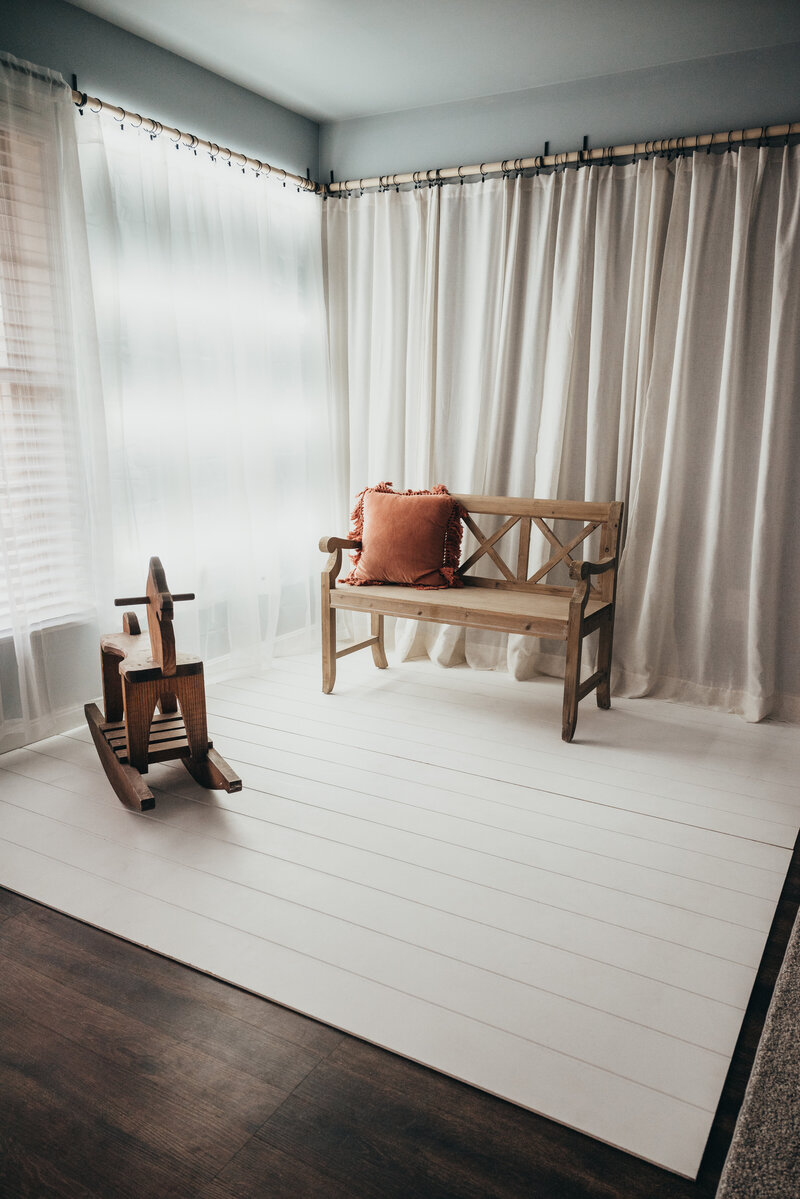 Photo of bench and rocking horse in moody studio in Severn Maryland