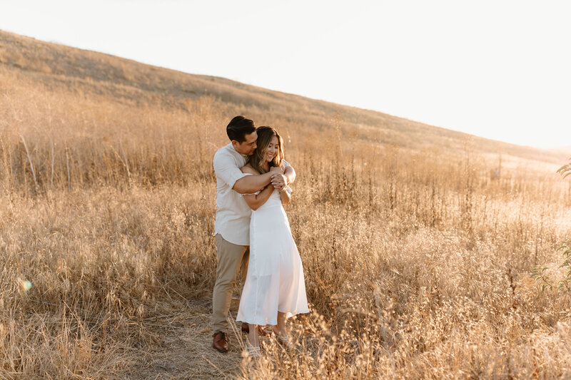 couple hugging in grass field