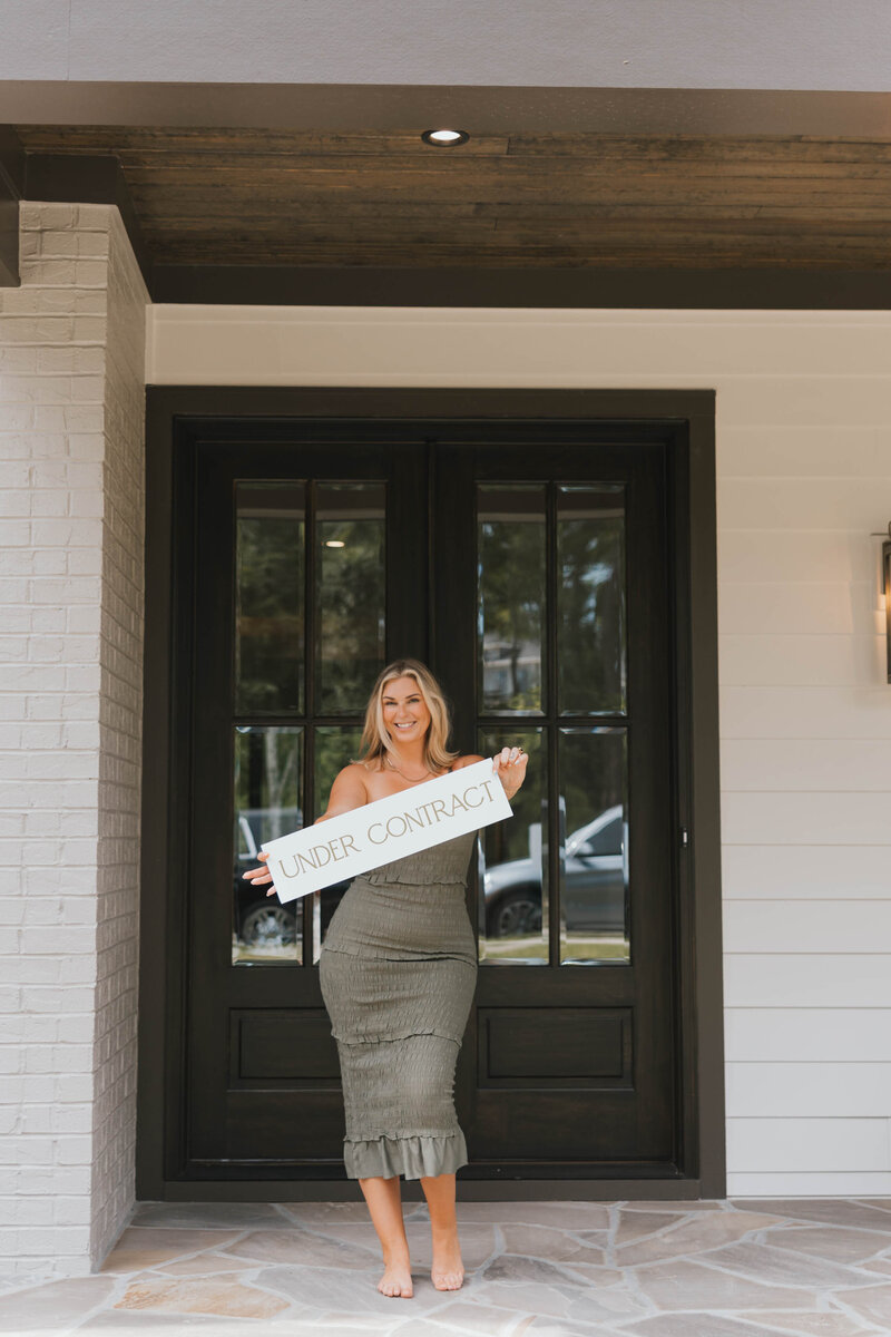 Jacie Dykes, raleigh realtor, standing outside next to Jacie and Company For Sale home in Raleigh, nc.