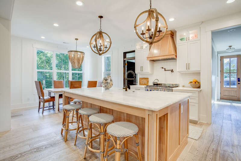 A stylish kitchen island with bar stools, offering a view into a more formal seating area. The design seamlessly blends casual and formal spaces, creating an inviting and versatile environment for both cooking and entertaining.