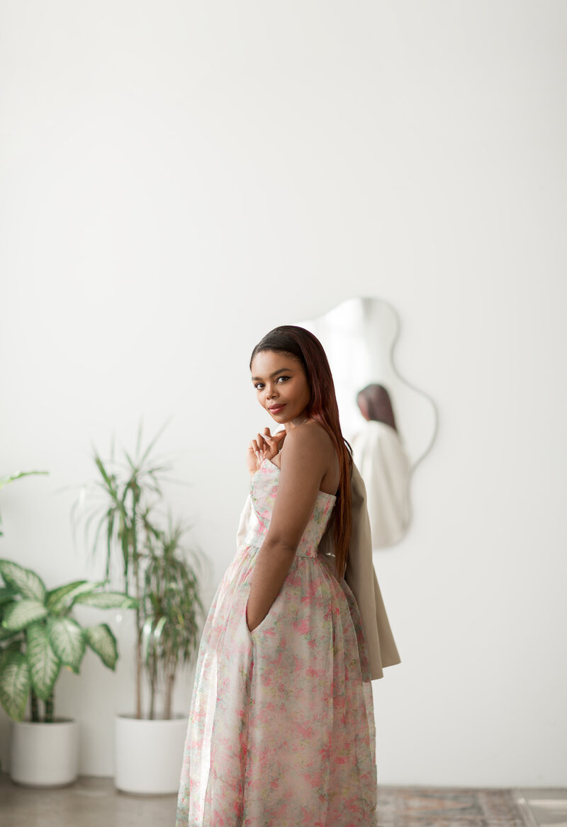 Tahirah smiling in front of a bouquet of colorful flowers