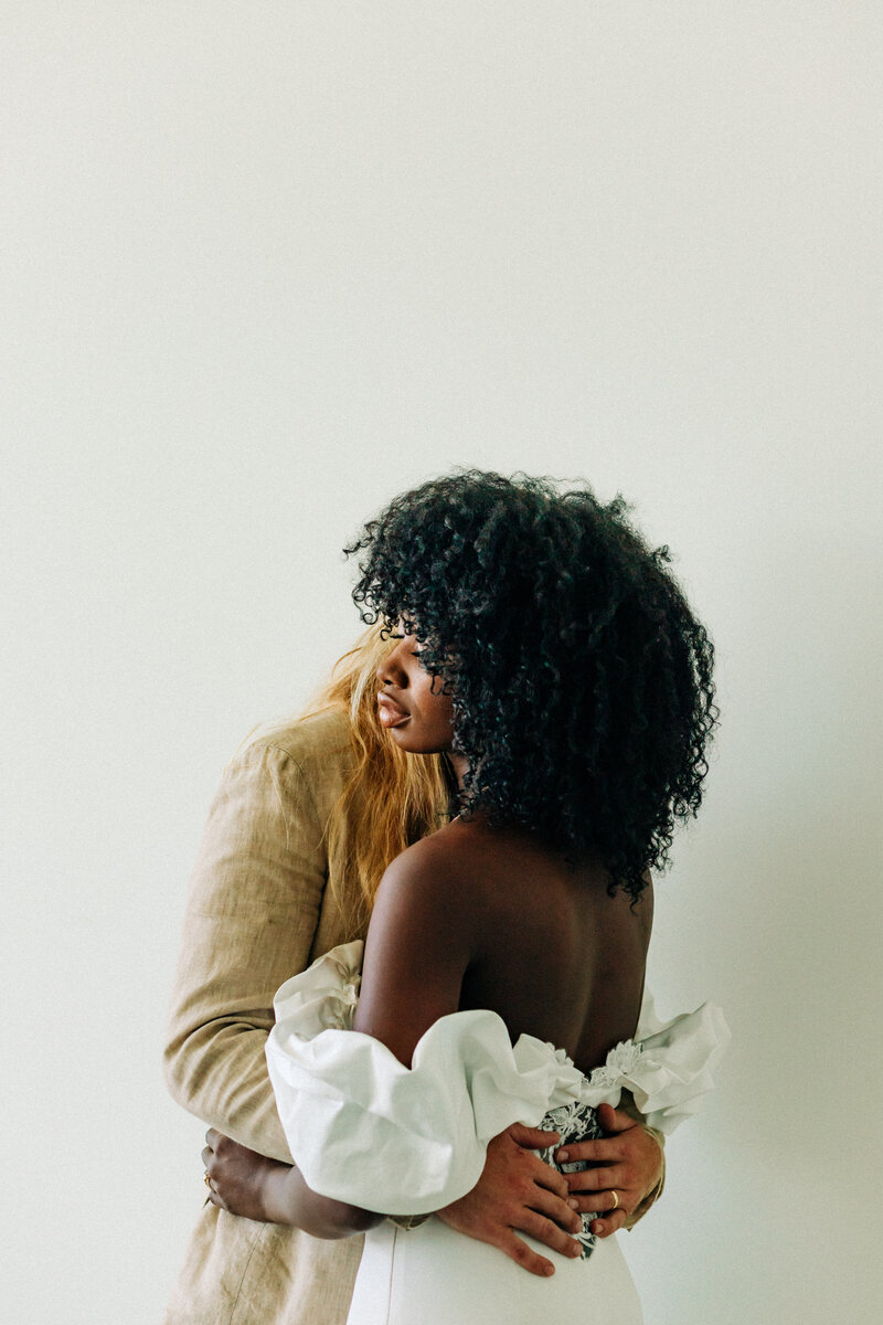 afro having black woman embracing husband