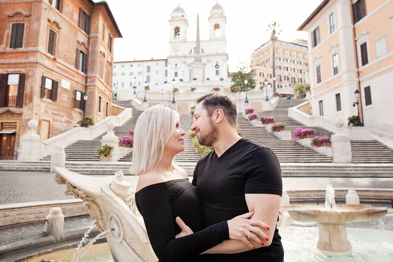 A couple embracing at the bottom of the Spanish Steps in Rome. Taken by Rome Photographer, Tricia Anne Photographer