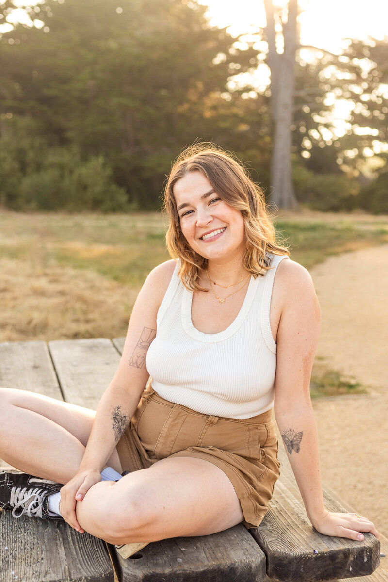 person smiling and pushing their hair back over one ear