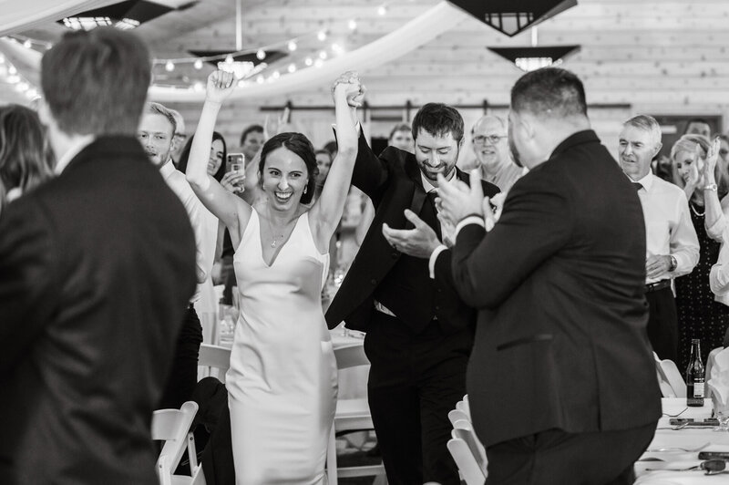 bride and groom holds hands while walking through people clapping