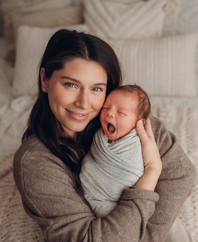 mom holdig yawning newborn baby