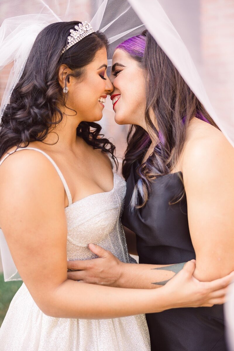 two brides smiling at wedding