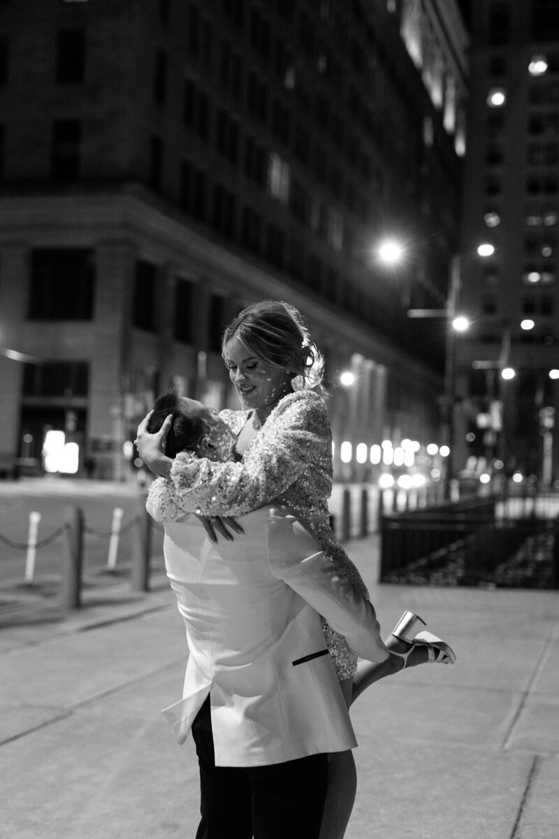 Groom picking bride up on Broad St in Philly at night