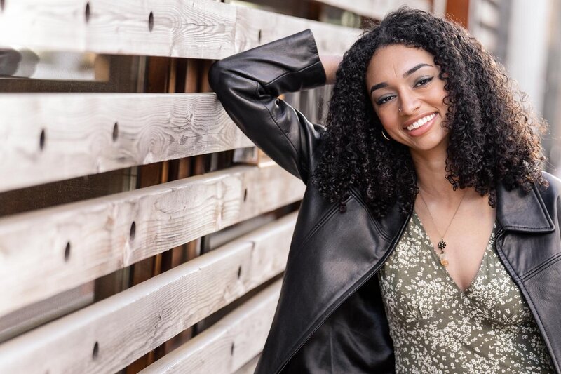 girl leaning on the wooden wall during Reston Town Center, VA senior photos