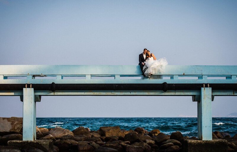 bride and groom sitting on the bridge