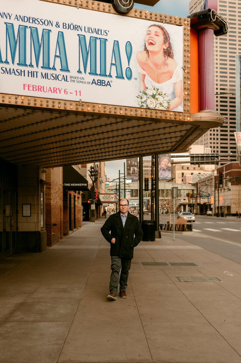 Minneapolis dating photography capturing Ryan walking confidently through the city streets.