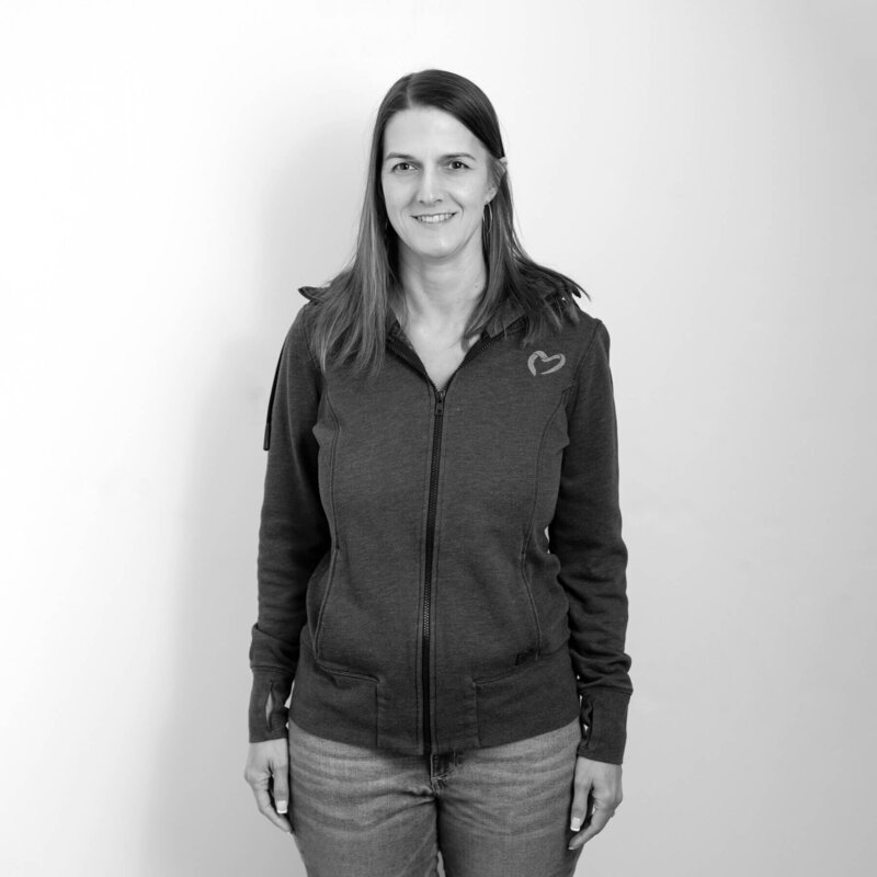 Black and white portrait of a woman in a hoodie, natural expression.