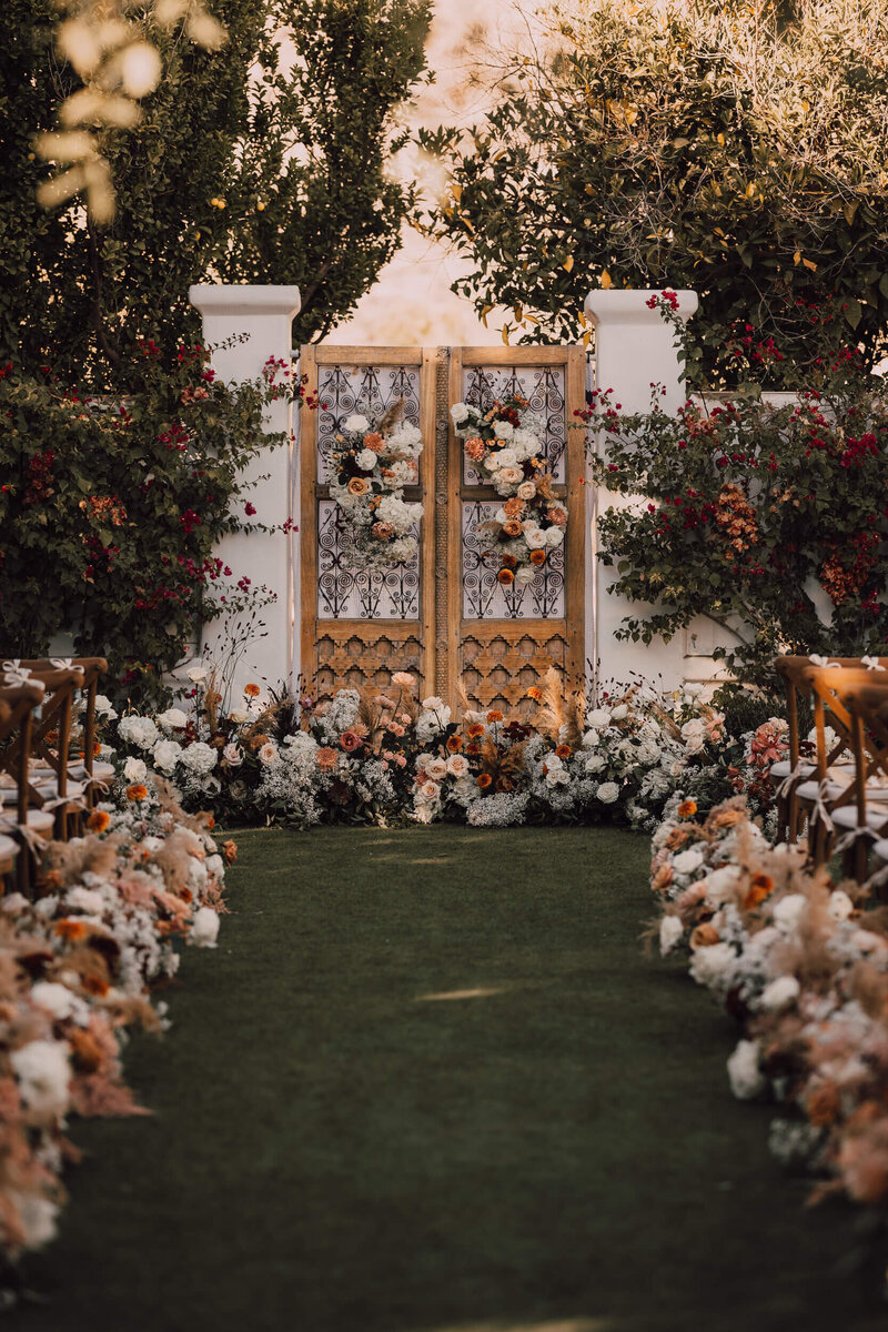 Ceremony aisle with earthy colour palette florals at Arizona wedding