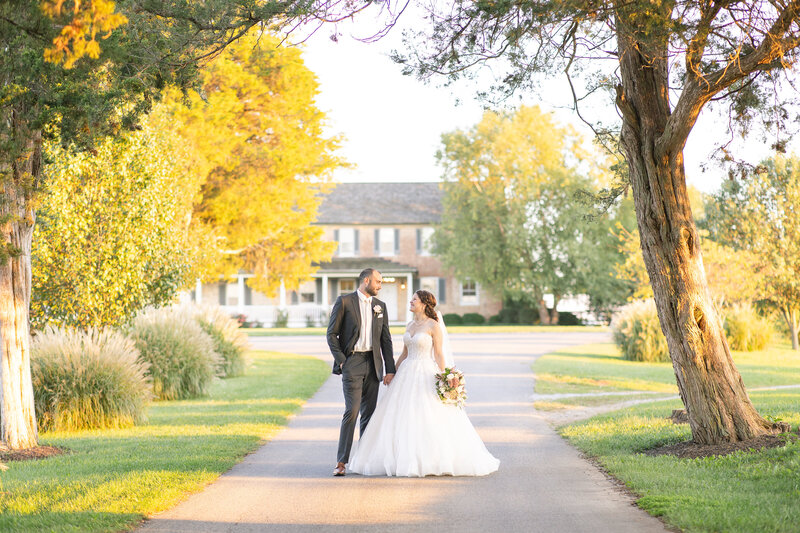 bride and groom in front of beautiful house at sunset