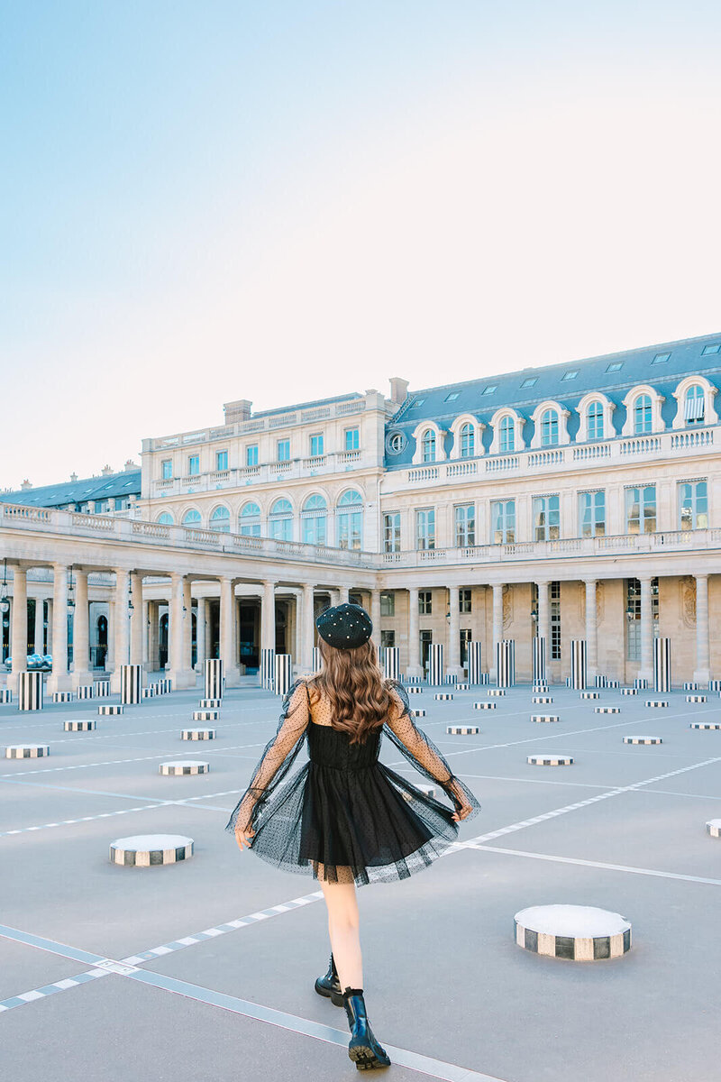 Solo female traveler wearing a floaty net dress, Doc Martens, and a French beret during a Paris photoshoot near the Eiffel Tower, Louvre, and Palais Royal.