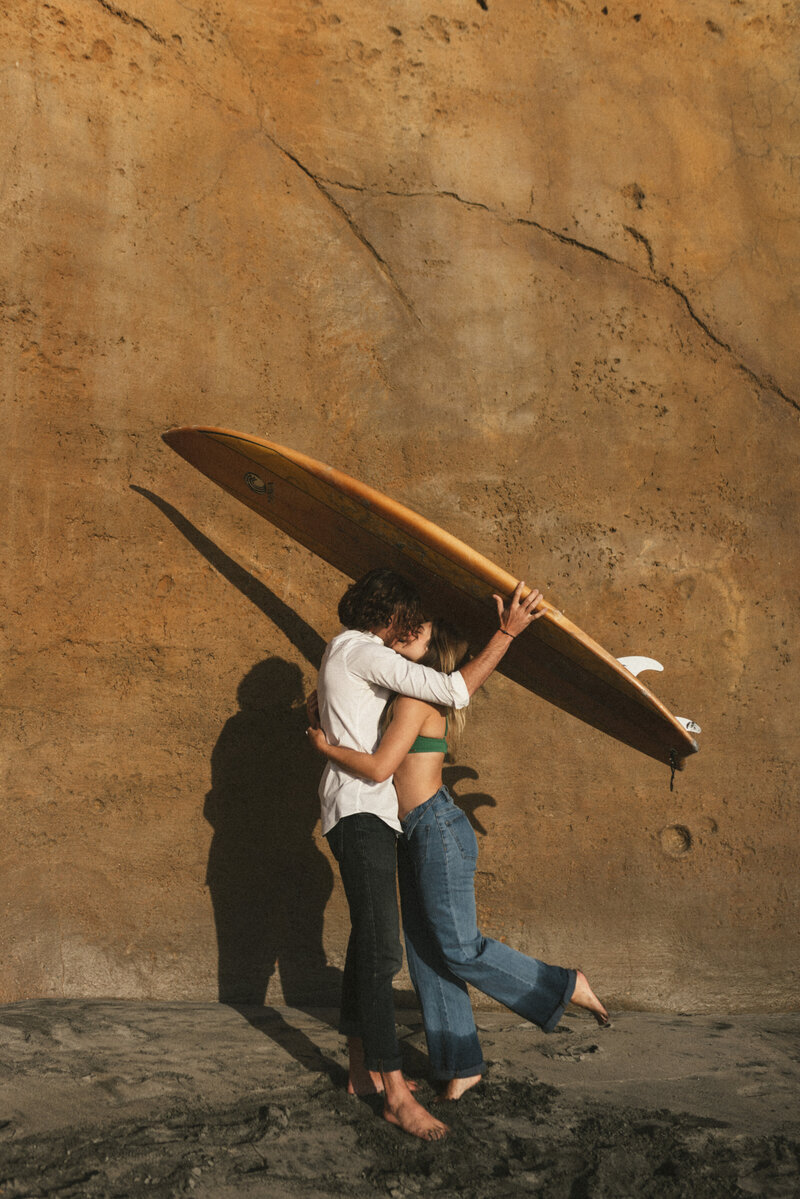 couple-holding-surfboard-during-a-photoshoot