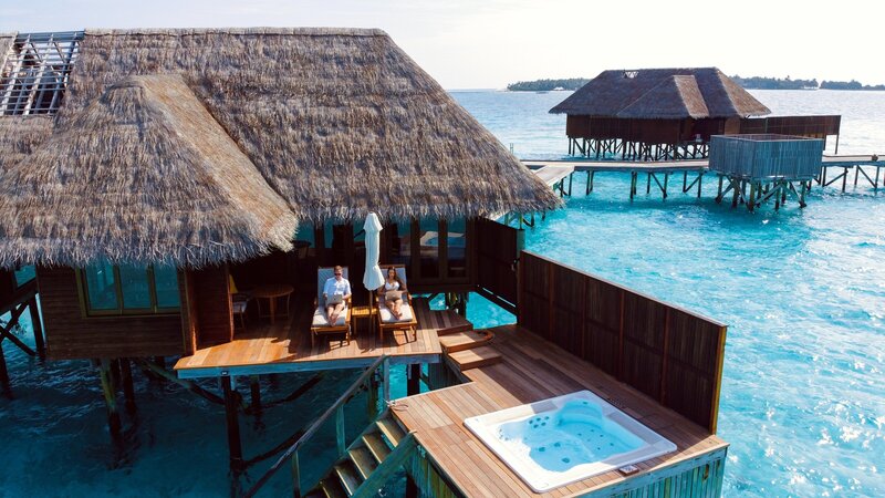 a man and woman sitting under a cabana