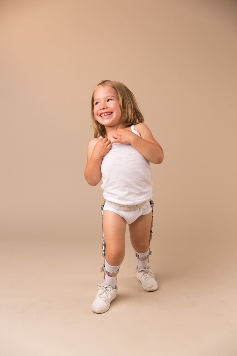 Photo of little girl in leg braces happy and smiling