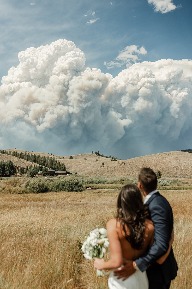 Photo of bridge and groom overlooking the mountains