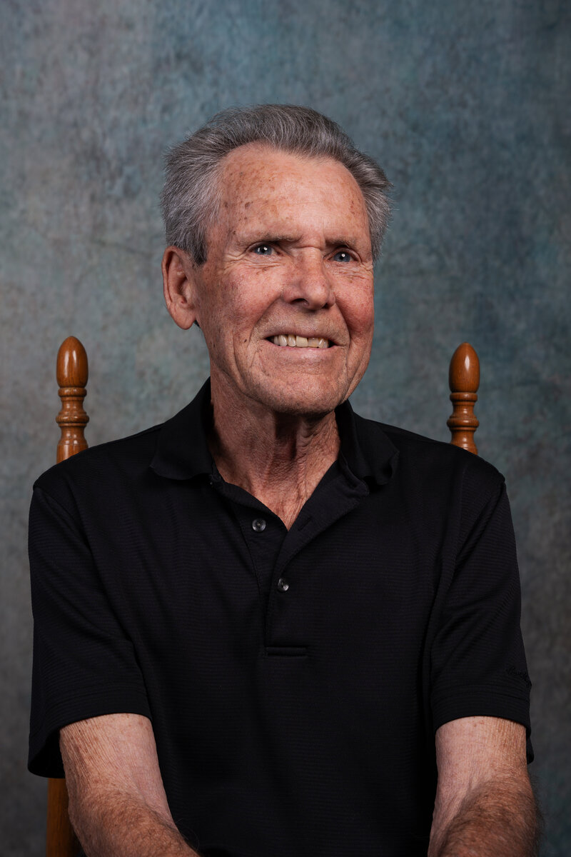 a photo of an elder man smiling in a photo studio