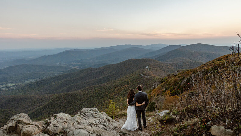 An eloping couple standing on top of Stony Man admiring the Allegheny Mountains in the distance