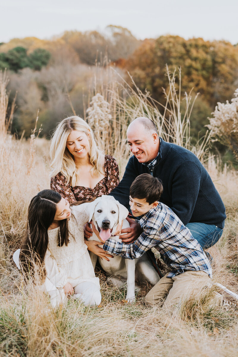 Family with two young children and yellow lab pose together during Fall family photo session