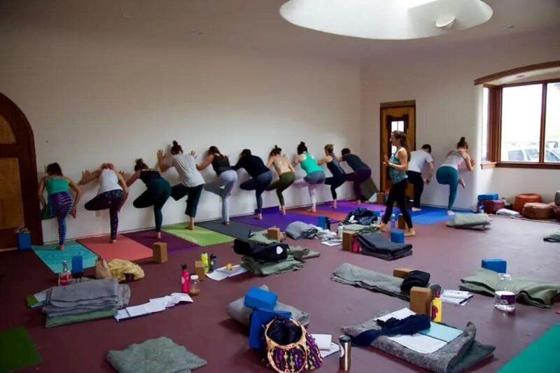 Students practicing accessible figure four variation during hatha yoga teacher training California