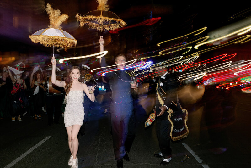 bride and groom holding umbrellas during second line New Orleans wedding