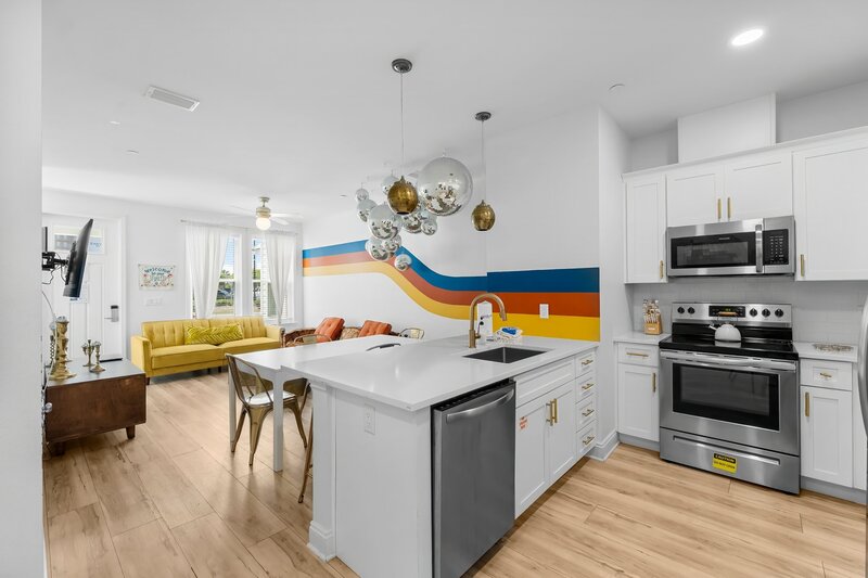 View from kitchen to living room with bold wall stripes and disco ball ceiling in Groovy Shack, vacation rental close to 30A and Pier Park