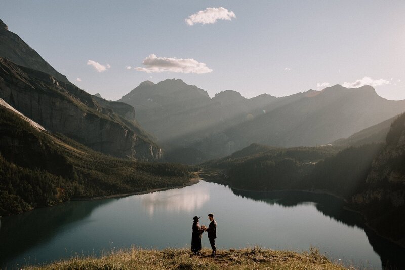 A couple embracing in front of a moody Scottish Highlands