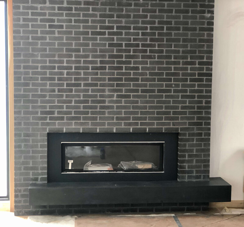 Floating concrete hearth and bench around a brick fireplace