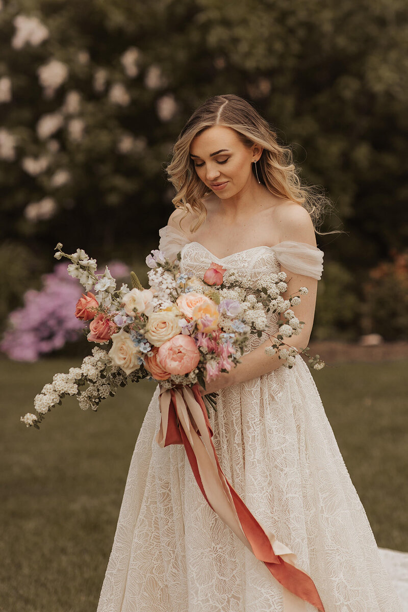 Bride with a colorful bouquet in an outdoor setting.