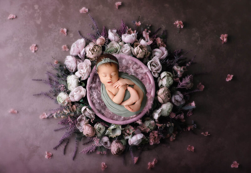newborn baby surrounded by purple floral  in hamilton, ON newborn studio